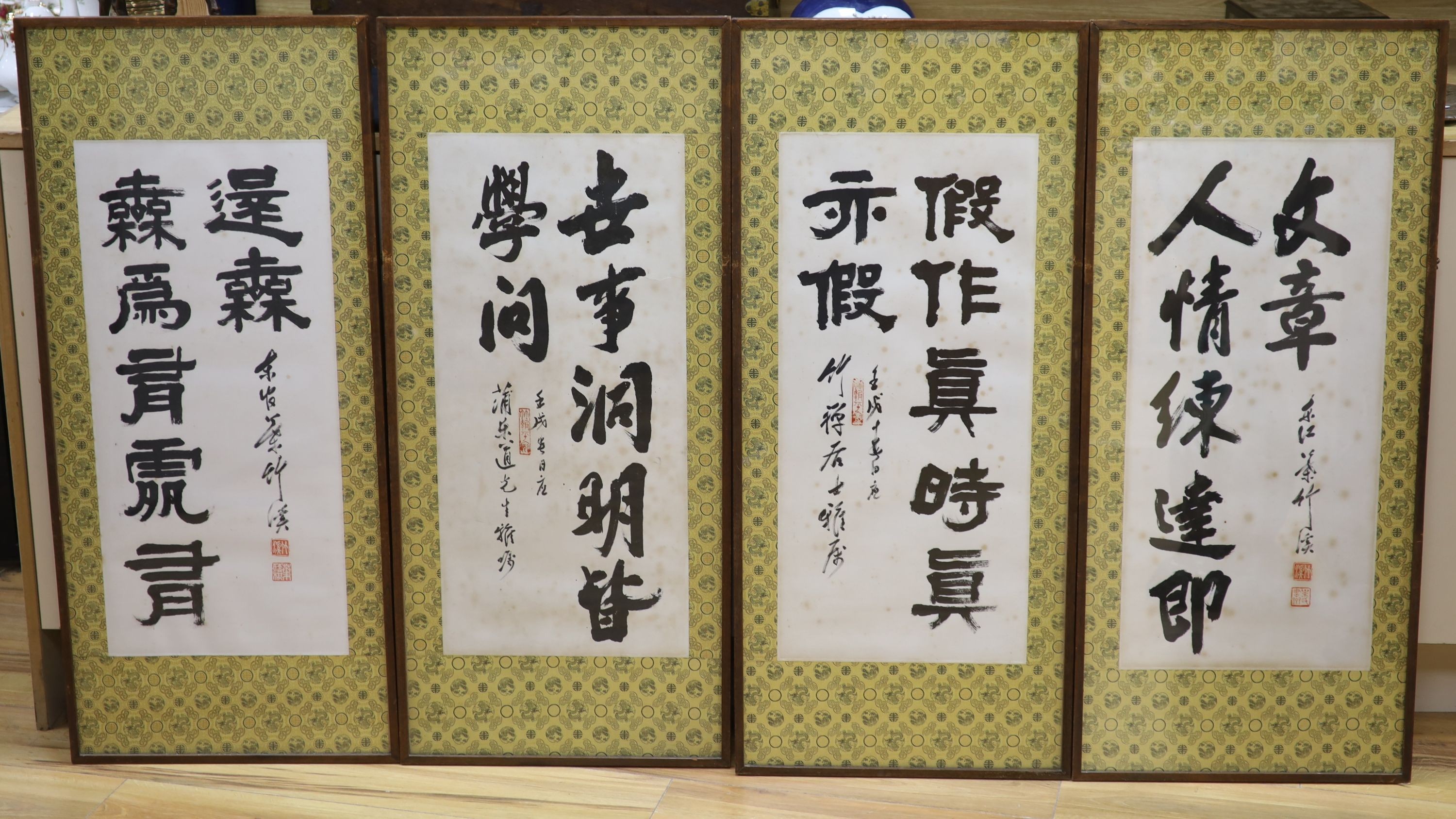 A set of four Chinese calligraphic ink paintings, each 80 x 32 cm excluding brocade borders